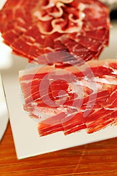 Thin slices of cured jamon on serving plate