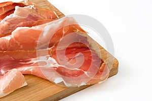 Thin slices of spanish serrano ham on a table isolated on white background