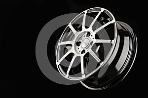 Thin-spoke cast disc, sports wheel on a black background, minimalism.