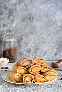 Thin spring rolls on a light concrete background. Platbands. National, traditional dish of Belarus and Ukraine. Pancakes