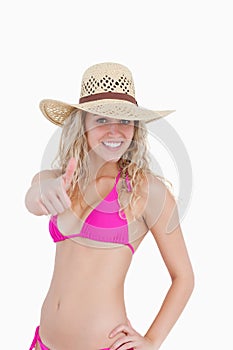 Thin teenager in beachwear showing her thumbs up