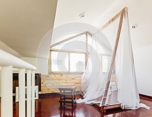 Thin white fabric with wooden structure tent inside the house with natural light from window