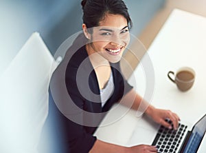 Things are looking up. High angle portrait of an attractive young businesswoman working on a laptop in her office.
