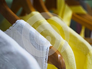 Things made of natural linen in different colors hang on hangers in the store