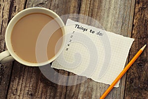 Things to do list, inscription. Blank papper and cup of coffee, over rustic wooden background, conceptual