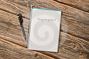 Things to get done write on a page of a spiral notebook on a wooden background