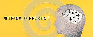 Think different stands on the yellow background, head with brain, being a nonconformist, standing out from the crowd, creative photo