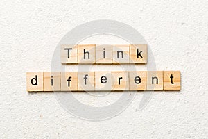 think different word written on wood block. think different text on table, concept