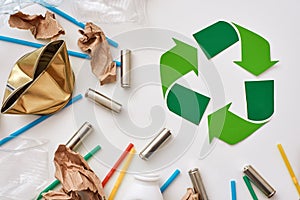 Think about ecology. Crumple paper, plastic and batteries near recycle symbol