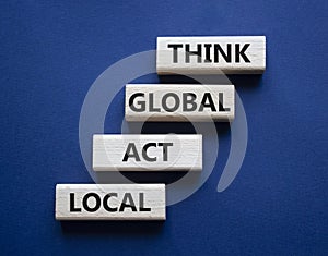 Think global act local symbol. Wooden blocks with words Think global act local . Beautiful deep blue background. Business and