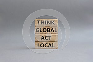 Think global act local symbol. Wooden blocks with words Think global act local. Beautiful grey background. Business and Think