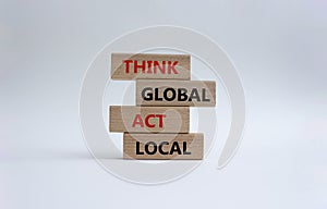 Think global act local symbol. Wooden blocks with words Think global act local. Beautiful white background. Business and Think