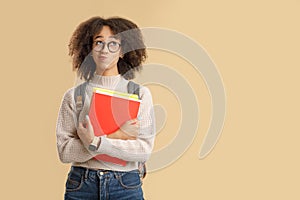 Think and make decisions. Pensive african american lady in glasses with smart watch and backpack holding notebooks