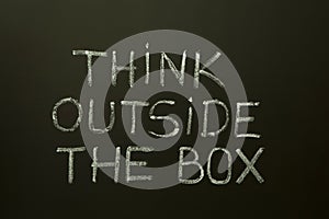 THINK OUTSIDE THE BOX on a blackboard