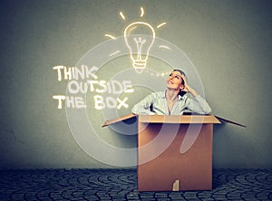 Think outside box. Woman coming out of box with great idea