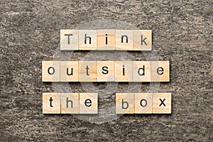 Think outside the box word written on wood block. Think outside the box text on cement table for your desing, Top view