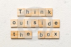 Think outside the box word written on wood block. Think outside the box text on cement table for your desing, Top view