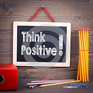 Think positive. Chalkboard on a wooden background