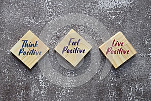 THINK POSITIVE, FEEL POSITIVE and LIVE POSITIVE on the wooden blocks. Lifestyle concept