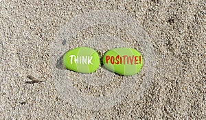 Think positive symbol. Concept words Think positive on beautiful green stone. Beautiful sea sand beach background. Business,