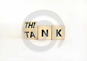 Think tank symbol. Businessman turns wooden cubes and changes the word Tank to Think or vice versa. Beautiful white table white