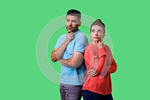 Think up plan! Portrait of smart attractive young couple in casual wear thinking together. isolated on green background