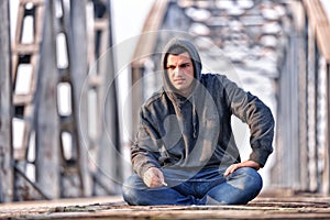 Thinker teenager in depression sitting down on the bridge at the