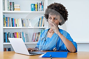 Thinking afro american nurse or medical student at computer