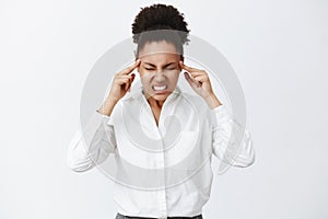 Thinking with all brain power. Portrait of intense focused serious-looking woman with dark skin in white-collar shirt