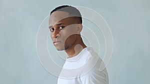 Thinking black Afro American man with serious expression looking with eyes directly into camera while posing against