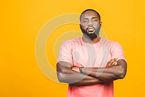 Thinking black Afro American man with serious expression looking, posing isolated against yellow background