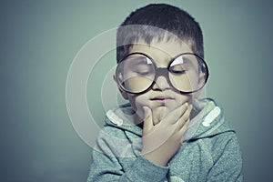 Thinking, boy with big glasses very serious and thinking