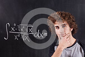 Thinking boy with blackboard solving equation