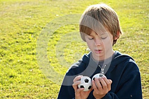 Thinking boy with two balls