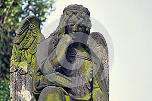 Thinking broody angel statue on Malostransky cemetery, Prague, Czech Republic