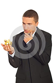 Thinking business man holding piggy bank