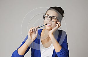 Thinking Business Woman Looking Up, Pensive Young Girl in Glasses Dream over Gray Background