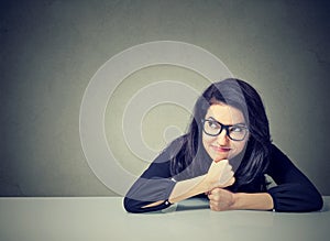 Thinking business woman sitting at desk