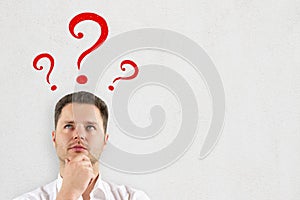 Thinking businessman with question marks