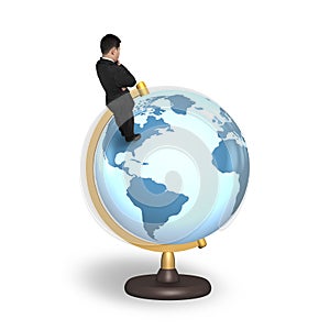 Thinking businessman standing on terrestrial globe