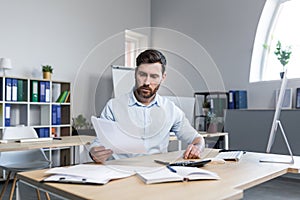 Thinking businessman working with documents in the office, man reviewing financial reports