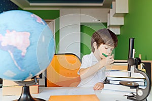 Thinking child bored, frustrated and fed up doing his homework