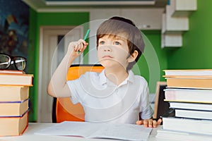 Thinking child bored, frustrated and fed up doing his homework