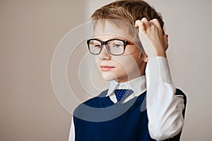 Thinking child portrait of a little boy age seven in glasses deeply about something looking up copy space above his hea