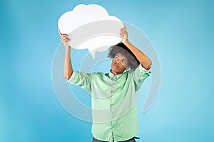 Thinking concept. Pensive african american guy holding and looking at speech bubble, pondering, blue background