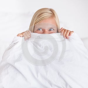 Thinking, eyes and happy woman in a bed with blanket, hiding or waking up playful in her home. Morning energy, hands and