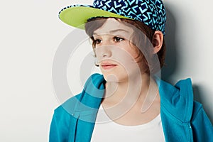 Thinking, fashion and young child in a hoodie in studio  on a white background. Trendy style, cool kid and cap
