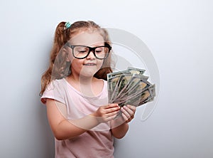 Thinking fun small kid girl in glasses counting money in the han