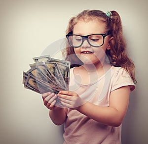 Thinking fun small kid girl in glasses counting money in the han