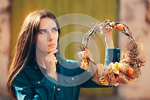 Thinking Girl Holding Decorative Autumn Wreath